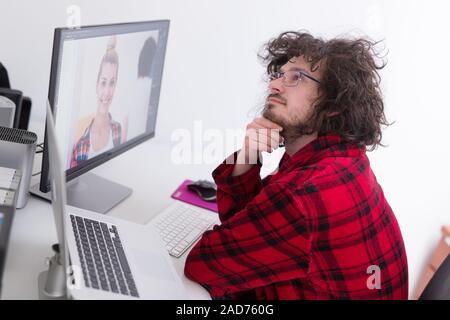 Graphic designer in accappatoio a lavorare a casa Foto Stock