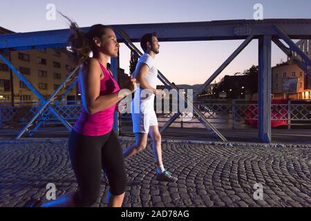 Giovane jogging attraverso il ponte della città Foto Stock