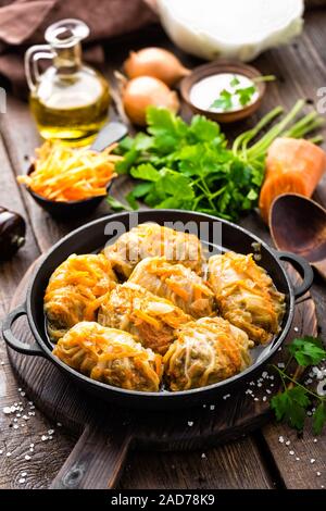 Involtini di cavolo stufato con la carne e le verdure in padella in scuro dello sfondo in legno Foto Stock