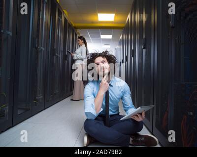 Giovani tecnici che lavorano insieme su server Foto Stock