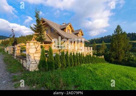 In legno tradizionale casa di montagna costruita da ciocchi di legna in estate giornata di sole Foto Stock