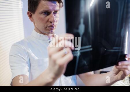 Il medico guarda il paziente di raggi x. Il lavoro del medico della clinica Foto Stock