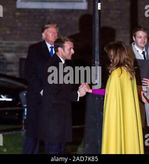 Il Presidente francese Emmanuel Macron ci saluta la first lady Melania Trump come il presidente statunitense Donald Trump guarda su come essi arrivano per un ricevimento serale per i leader della NATO hanno ospitato dal Primo Ministro Boris Johnson a 10 Downing Street London, come i leader della NATO si riuniscono per contrassegnare 70 anni di alleanza. Foto Stock