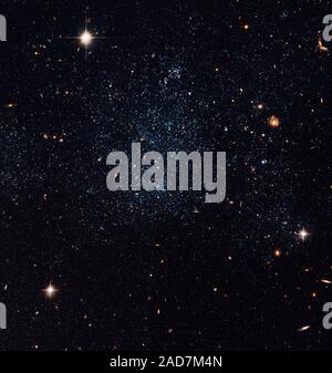 Questo sciolto raccolta di stelle è in realtà una nana galassia irregolare, chiamato Holmberg IX. Si trova appena fuori del bordo esterno di M81, una grande galassia a spirale nell'Orsa Maggiore. Questa immagine è stata scattata con Hubble della fotocamera avanzate per le indagini nei primi mesi del 2006. Holmberg IX è del cosiddetto tipo Magellanic della galassia, come la sua dimensione e irregolarità nella struttura sono simili a piccoli Magellanic Cloud, un vicino alla nostra Via Lattea. Holmberg IX fu scoperta per la prima volta dall'astronomo Sidney van den Bergh nel 1959, e catalogati come DDO 66. Il Galaxy ha ricevuto il suo 'Holmberg IX' naming quando è stato discusso in Eric Foto Stock