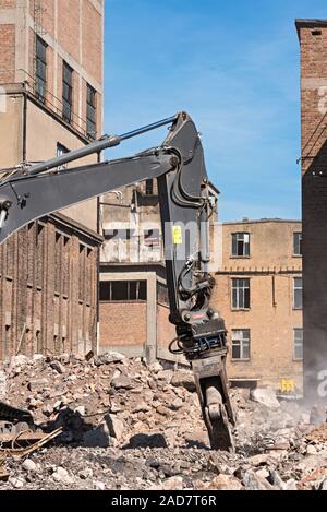 Demolizione la benna mordente di un escavatore in un cantiere durante i lavori di demolizione Foto Stock