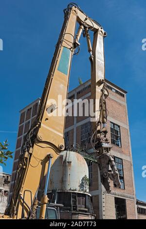 Pinze di demolizione su un escavatore su un sito in costruzione Foto Stock