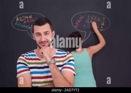 Incinta giovane scrivere su una lavagna Foto Stock