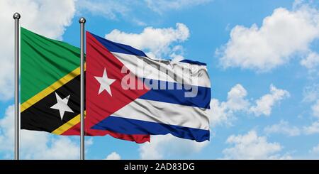 Saint Kitts e Nevis e Cuba bandiera sventolare nel vento contro bianco torbido cielo blu insieme. Concetto di Diplomazia e relazioni internazionali. Foto Stock