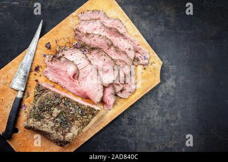 Pranzo Tradizionale di carne con affettati misti arrosto di manzo come vista dall'alto su un tagliere con spazio copia a destra Foto Stock