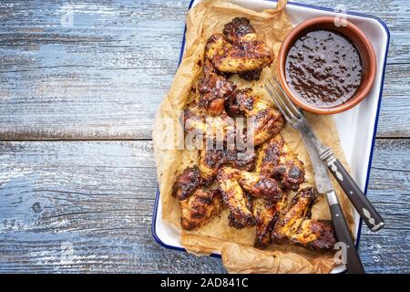 Barbecue tradizionale di ali di pollo con peperoncino Salsa di vista superiore in una padella con copia spazio a sinistra Foto Stock