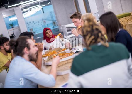 Multietnica team aziendali di mangiare la pizza Foto Stock