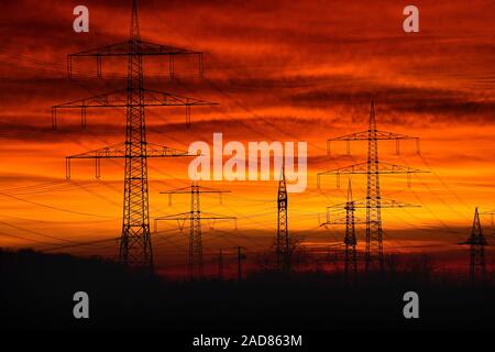 Tramonto sulla linea di alimentazione e la linea ad alta tensione sul Dinkelberg nella Germania meridionale Foto Stock