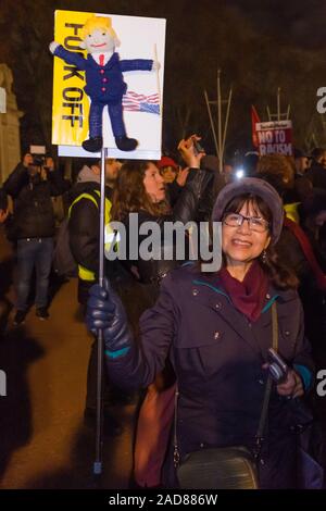 Londra, Regno Unito. Il 3° dicembre 2019. Una donna che tiene un cartello con un wooly Trump su di esso rivolta verso Buckingham Palace. Dopo il rally in Trafalgar Square oltre un migliaio di persone hanno marciato verso il basso al centro commerciale per protestare fuori i leader della NATO hanno la cena nel Palazzo di Buckingham. Nonostante il marzo sia stato concordato dalle forze di polizia in anticipo è stato arrestato varie volte dalle forze di polizia e le barriere e trattenuti per mezz'ora per un singolo taxi a lasciare, raccogliere qualcuno e tornare al Mall. Alla fine i manifestanti sono stati ammessi a unirsi a quelle già di fronte al palazzo di fronte al cancello del Canada in cui una forte protesta continu Foto Stock