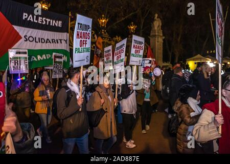 Londra, Regno Unito. Il 3° dicembre 2019. Palestina solidarietà dimostranti entrano nell'area di protesta rivolta verso Buckingham Palace. Dopo il rally in Trafalgar Square oltre un migliaio di persone hanno marciato verso il basso al centro commerciale per protestare fuori i leader della NATO hanno la cena nel Palazzo di Buckingham. Nonostante il marzo sia stato concordato dalle forze di polizia in anticipo è stato arrestato varie volte dalle forze di polizia e le barriere e trattenuti per mezz'ora per un singolo taxi a lasciare, raccogliere qualcuno e tornare al Mall. Alla fine i manifestanti sono stati ammessi a unirsi a quelle già di fronte al palazzo di fronte al Gate in Canada dove un forte segno di protesta Foto Stock