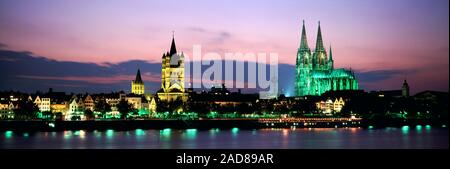 Paesaggio con la cattedrale di Colonia e al lordo la chiesa di St Martin di notte, Colonia, Germania Foto Stock