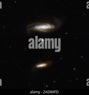 IC 2810 è un disco galaxy visto quasi di spigolo. È leggermente disturbata dalla interazione gravitazionale con un minore, polveroso companion (situato in fondo all'immagine.). La galassia più grande mostra nodi blu di formazione stellare. Anche se la coppia non ha alcuna regione di sovrapposizione al presente, è possibile che i due finiranno per collidere in futuro. IC 2810 si trova nella costellazione del Leone, il Leone, circa 450 milioni di anni luce di distanza. Questa immagine è parte di una grande collezione di 59 immagini di fusione di galassie prese dal Telescopio Spaziale Hubble e rilasciato in occasione della sua 18anni Foto Stock