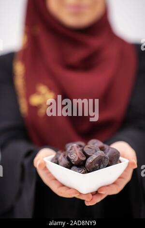 Moderna donna musulmana tenendo una piastra di date in ramadan kareem Foto Stock