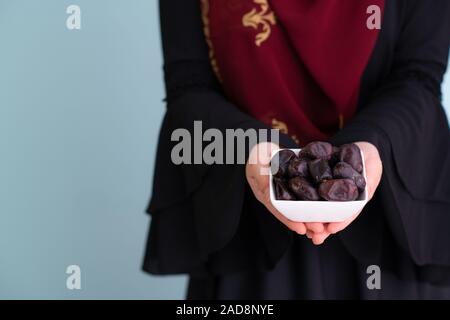 Moderna donna musulmana tenendo una piastra di date in ramadan kareem Foto Stock