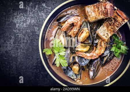 Tradizionale la Corsica francese stufato di pesce con gamberi e cozze come vista superiore in un design moderno ciotola con copia spazio a sinistra Foto Stock