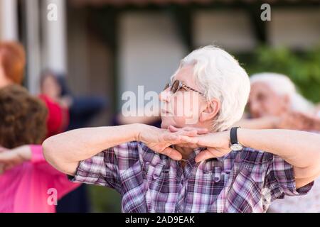 Senior donna esercita con gli amici Foto Stock