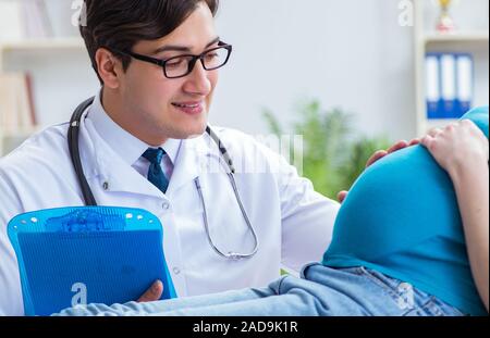 Medico esaminando femmine gravide di paziente in ospedale Foto Stock