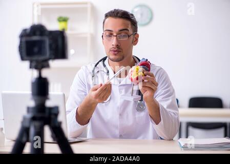 Giovane maschio medico cardiologo di registrazione di video per il suo blog Foto Stock