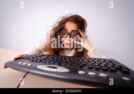 Funny nerd ragazza che lavora sul computer Foto Stock