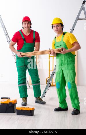 Due lavoratori gli appaltatori che lavorano in ambienti chiusi Foto Stock