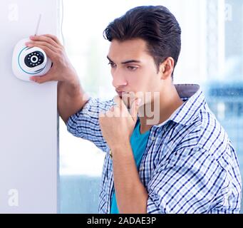 L'uomo installazione di sorveglianza telecamere TVCC a casa Foto Stock