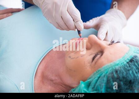 Vecchia donna visita medico maschio per la chirurgia plastica Foto Stock