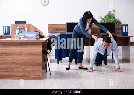 Dipendente di sesso maschile facendo sport esercizi in ufficio Foto Stock