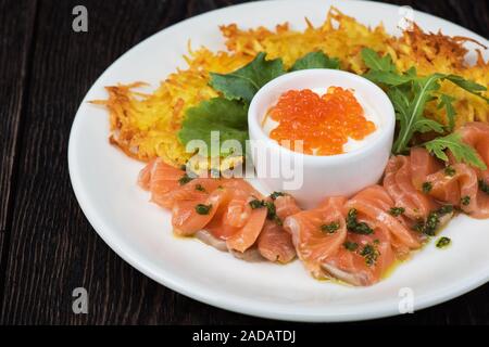 frittelle di patate, pesce di salmone e caviale rosso Foto Stock