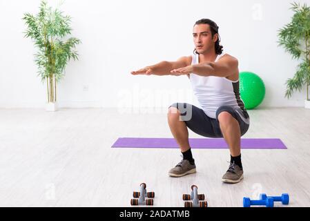 Giovane uomo bello fare sport esercizi in ambienti interni Foto Stock