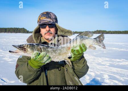 Chi detiene un grande pesce luccio in inverno. Inverno pesca di cattura trofeo attività outdoor hobby Foto Stock