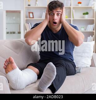 Uomo con gamba rotta recuperando a casa Foto Stock