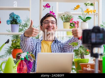 L'uomo fiorista giardiniere vlogger blogger riprese video sulla fotocamera Foto Stock