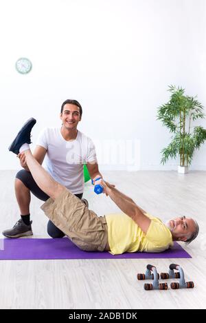 Il vecchio uomo facendo esercizi in ambienti interni Foto Stock