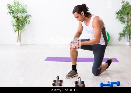 Giovane uomo bello fare sport esercizi in ambienti interni Foto Stock