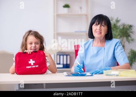 Bambina visitando il vecchio medico donna Foto Stock