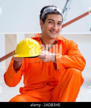 Il falegname che indossa il giallo hardhat contraente in officina Foto Stock