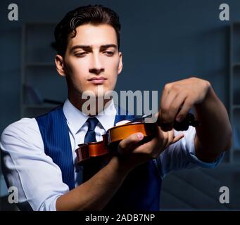 Giovane musicista man praticando suona il violino a casa Foto Stock