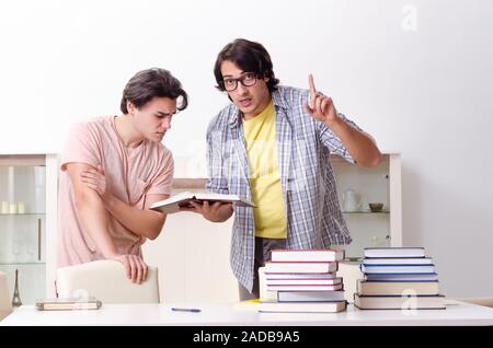 Due gli studenti di sesso maschile la preparazione per gli esami a casa Foto Stock