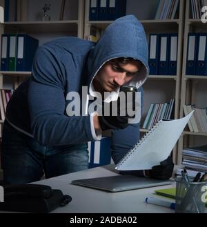 Giovane uomo in attività di spionaggio industriale concept Foto Stock