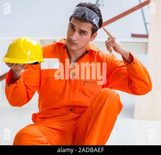 Carpenter indossando giallo hardhat contraente in officina Foto Stock