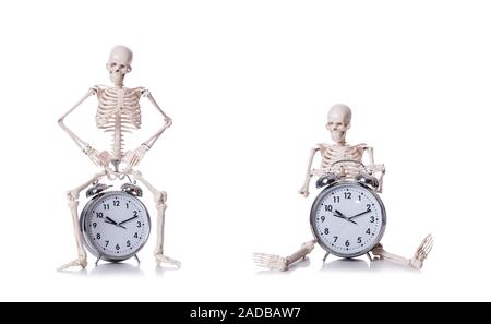Lo scheletro con la sveglia sul bianco Foto Stock