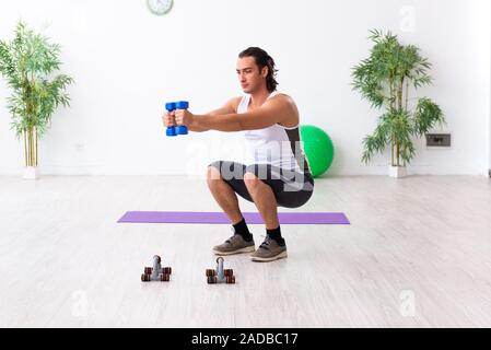 Giovane uomo bello fare sport esercizi in ambienti interni Foto Stock