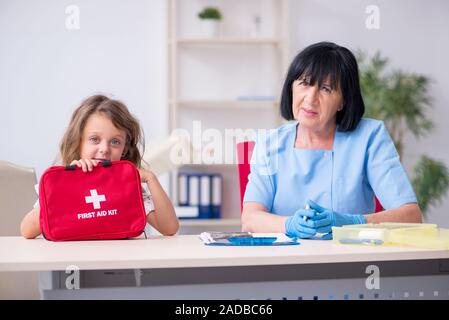 Bambina visitando il vecchio medico donna Foto Stock