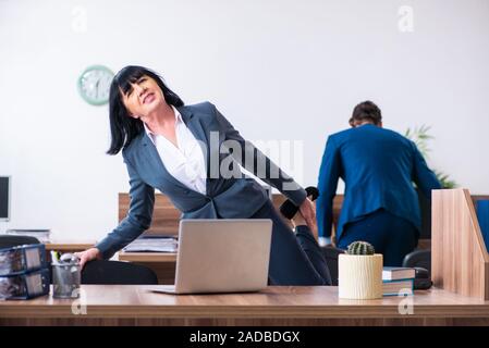 Due dipendenti facendo sport esercizi in ufficio Foto Stock