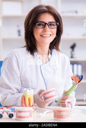 Donna dentista lavora sui denti impianto Foto Stock