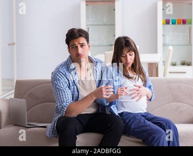 Donna incinta con il marito a casa Foto Stock